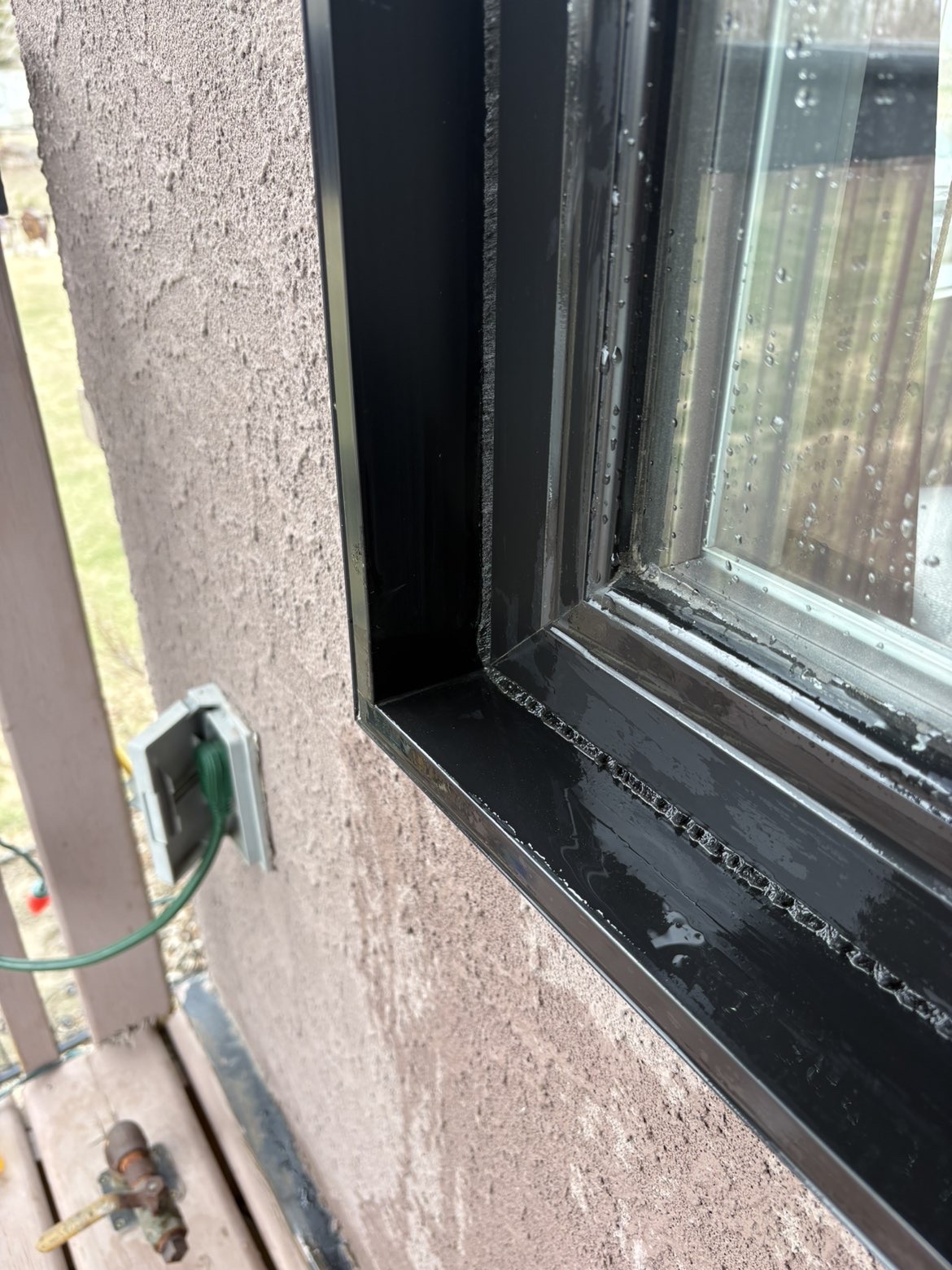 The lower corner of an exterior window frame and sill after cleaning